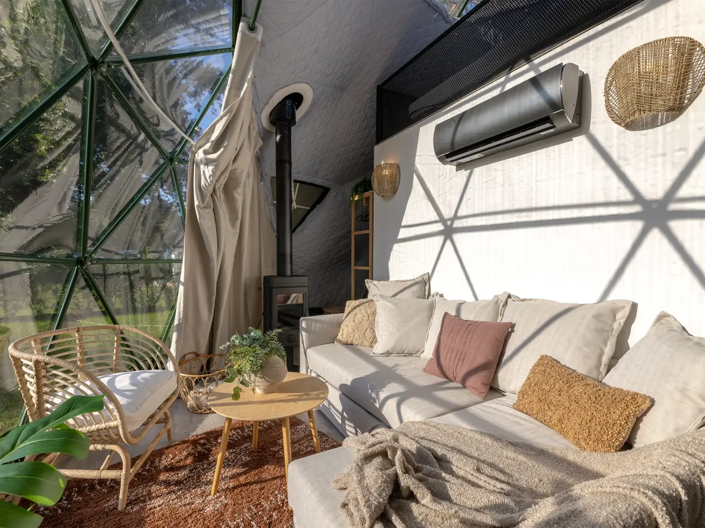 Inside the dome — sofa, rug, plant, and triangular panels filtering daylight