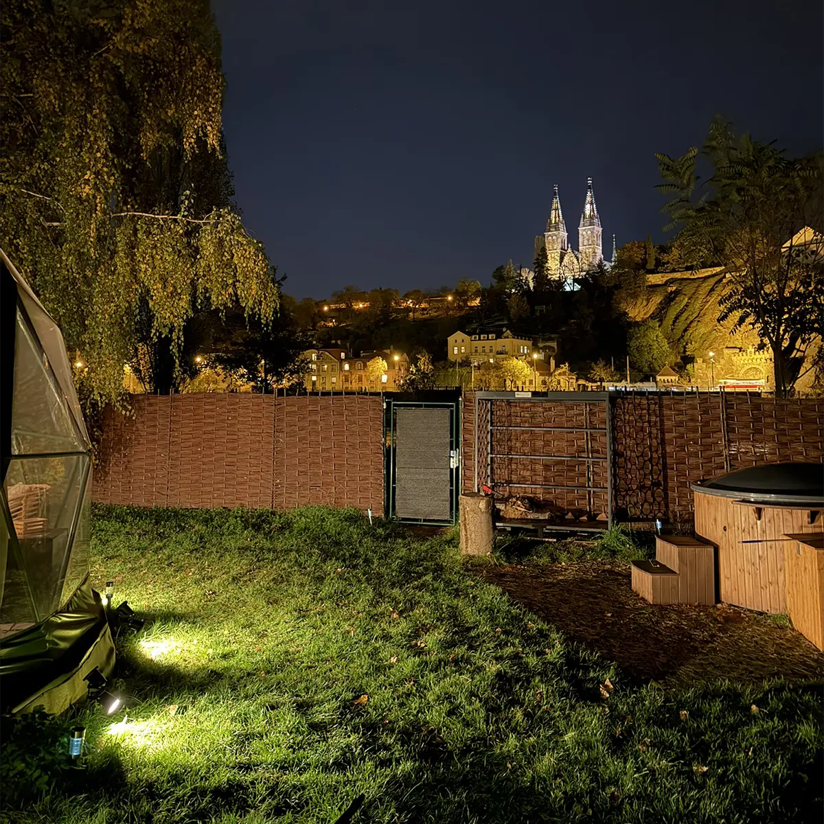 Night view of Vyšehrad from the deck, hot tub lit, fence and lawn lit